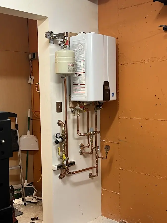 Plumbing technician inspecting water heater connections in Gary